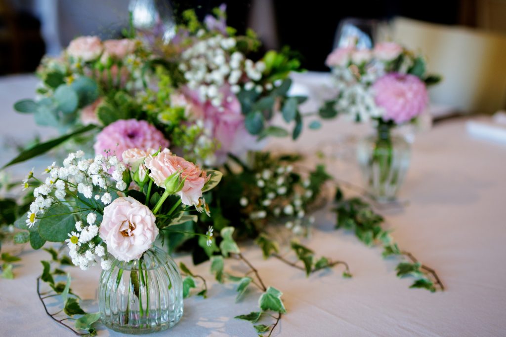 Des fleurs pour un mariage sont posés sur la table des mariés. Nous sommes au domaine La Capitaine avec l'artisan traiteur l'effervescence