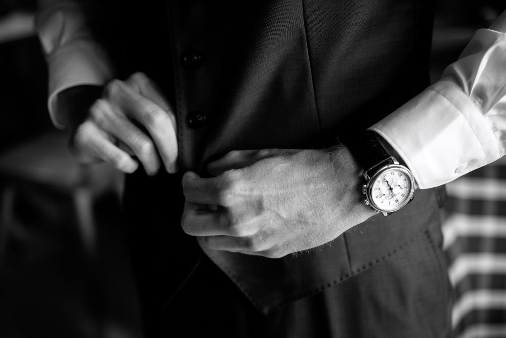Un futur marié est en plein dans ses préparatifs. Il est en train de s'habiller. On voit son costume, sa belle montre. La photo est en noire et blanc. Ca se passe à Champoussin, en Valais en Suisse. 